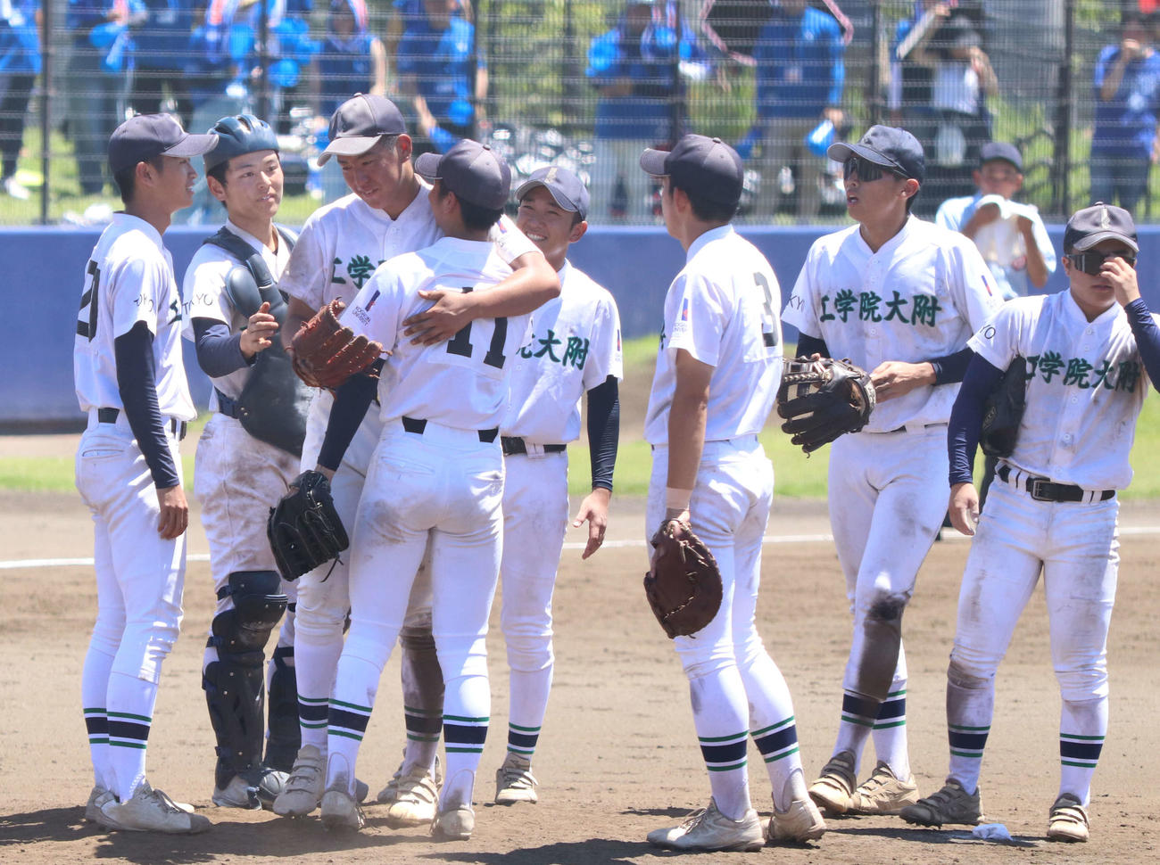 駒大高対工学院大付　降板前、2番手の鈴木＜11＞を抱きしめた工学院大付先発の岩月（左から3人目）（撮影・泉光太郎）