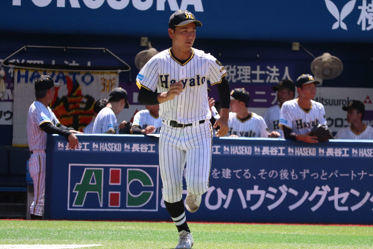 出塁した走者のレガースなどを取りに一塁へ全力疾走する横浜隼人の葛西（撮影・保坂淑子）