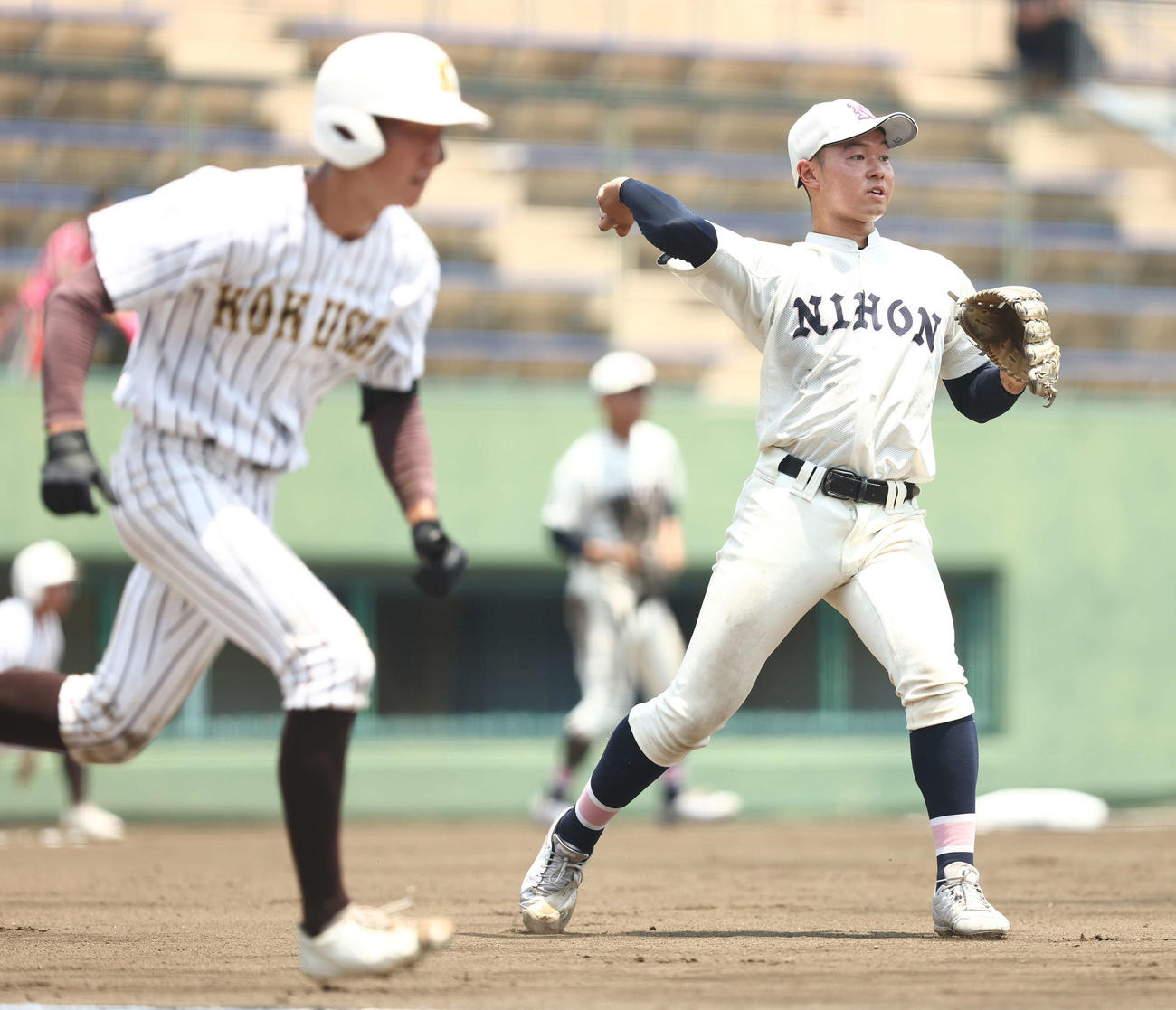 国士舘対日大鶴ケ丘　2回表国士舘無死一塁、高橋のバント球を一塁に送球する日大鶴ケ丘・小林（撮影・河田真司）