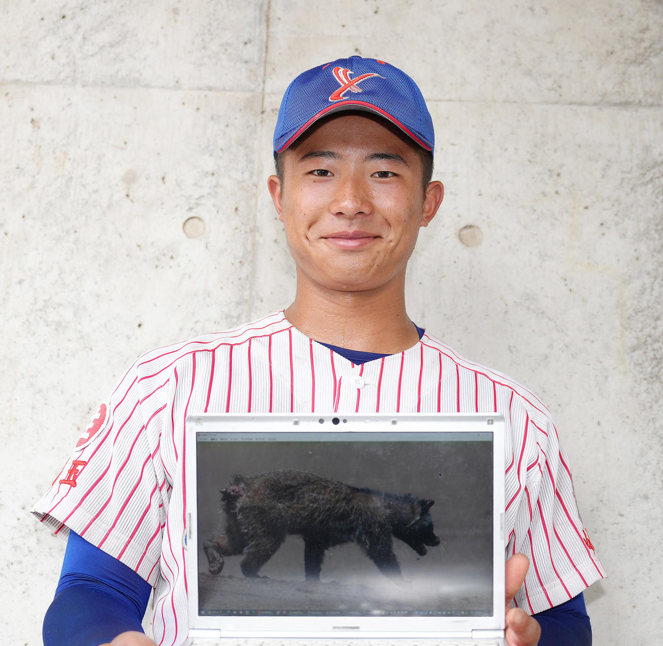 山村学園対西武台　試合後、グラウンドに侵入したハクビシンの画像を手に笑顔を見せる山村学園・横田（撮影・足立雅史）