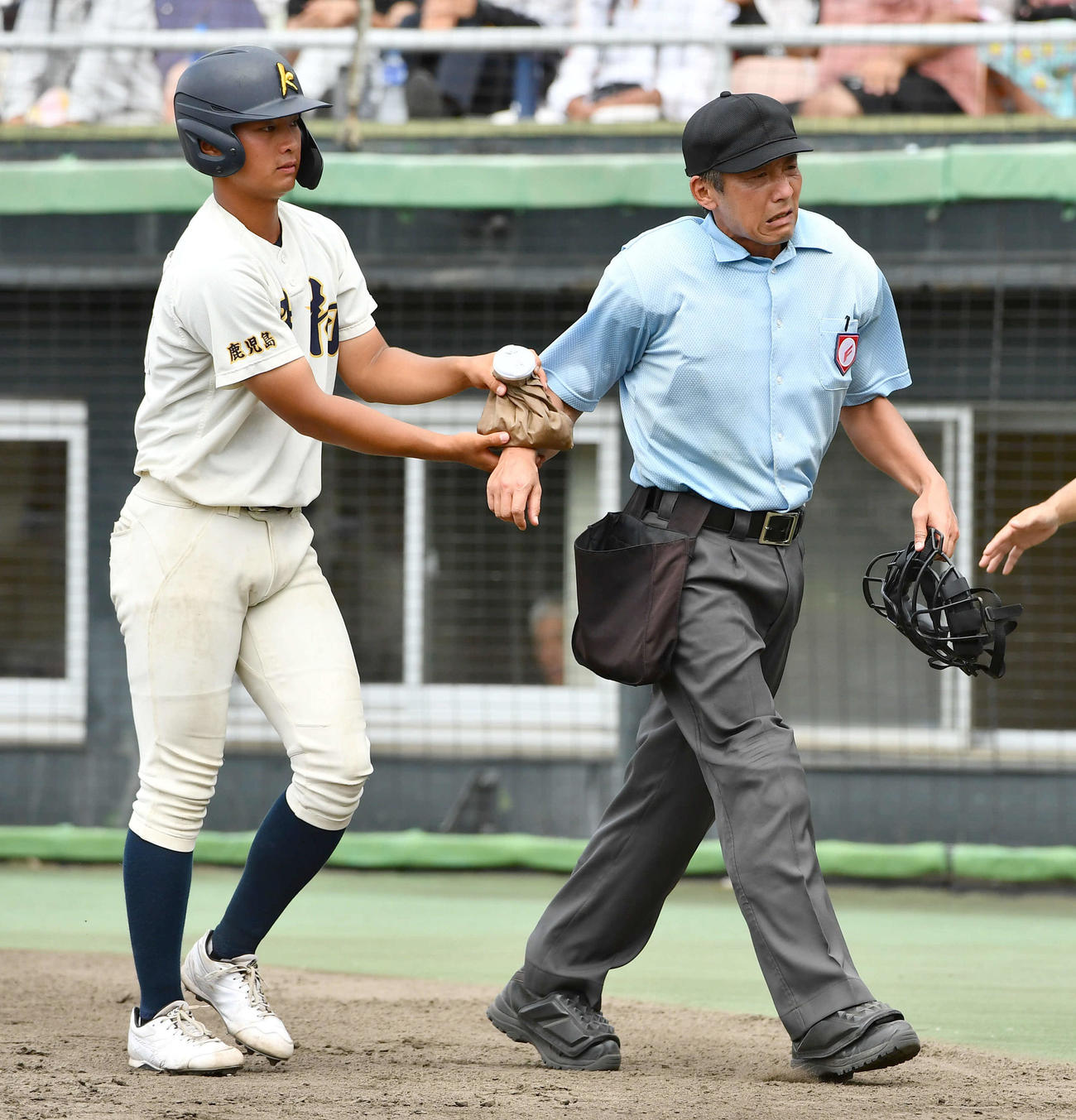 神村学園対れいめい　5回表神村学園2死三塁、今岡拓夢のファウルが右手に当たり、治療に向かう主審（撮影・岩下翔太）
