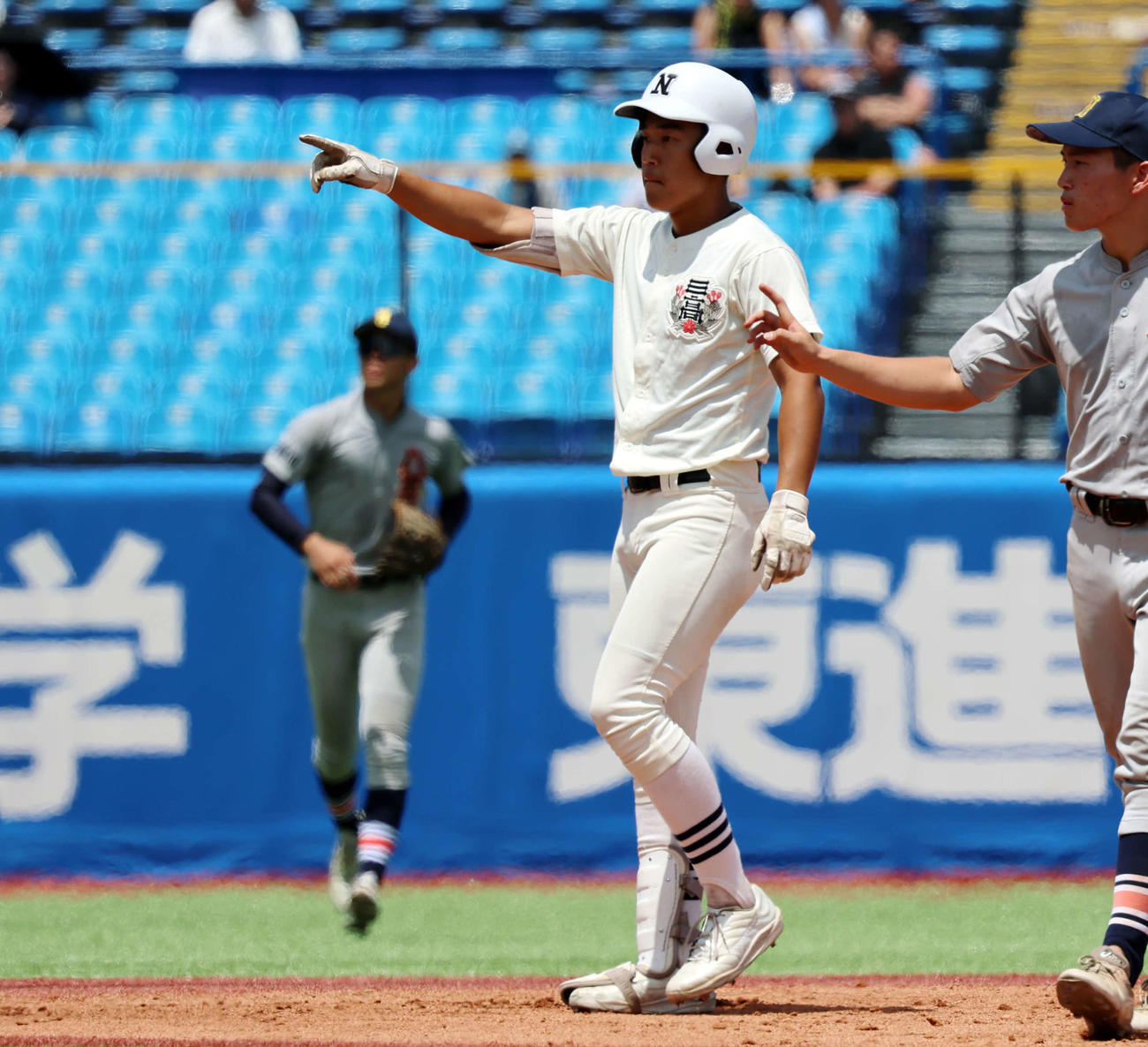 八王子対日大三　1回裏日大三1死三塁、先制の適時二塁打を放った本間（中央）はベンチを指さすポーズを取る（撮影・山本朝陽）