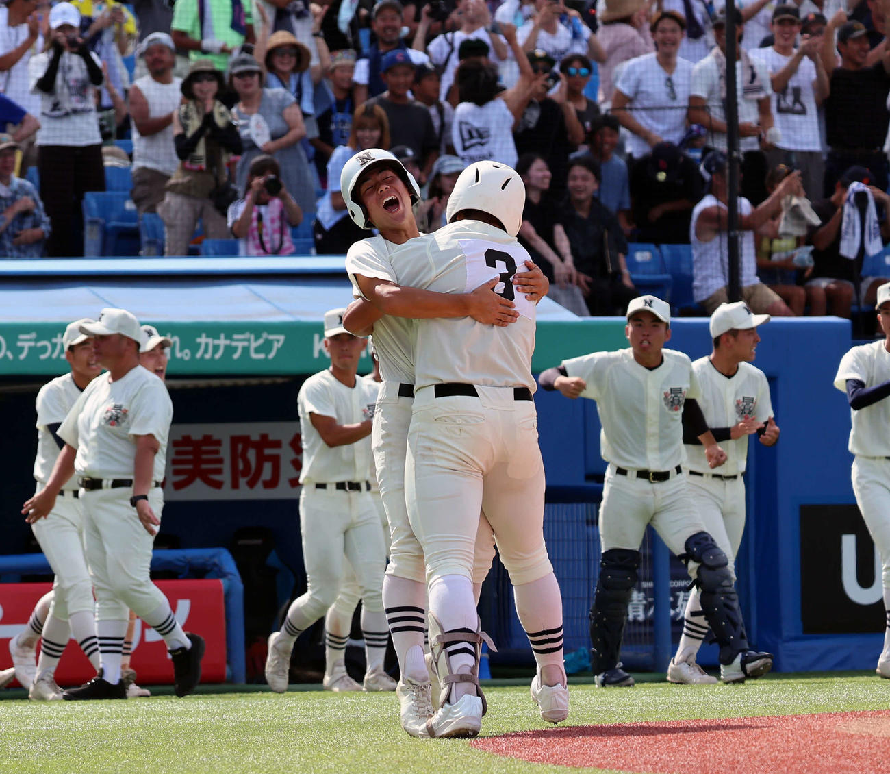 八王子対日大三　9回裏日大三無死一塁、サヨナラとなる2点本塁打を放ち生還した田中諒（手前）はナインと抱き合って喜ぶ（撮影・山本朝陽）