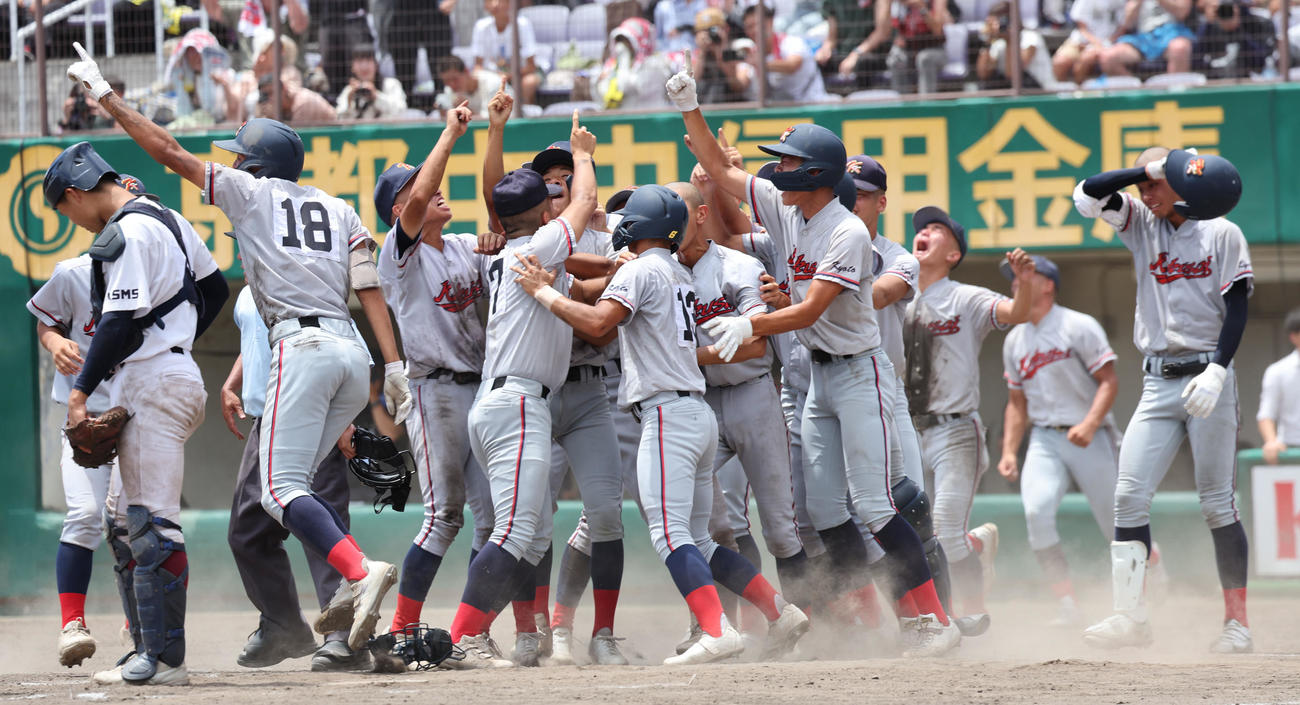 京都国際対鳥羽　9回裏サヨナラ勝ちで優勝を決め喜ぶ京都国際ナインの横で汗を拭う西村（右）（撮影・西尾就之）