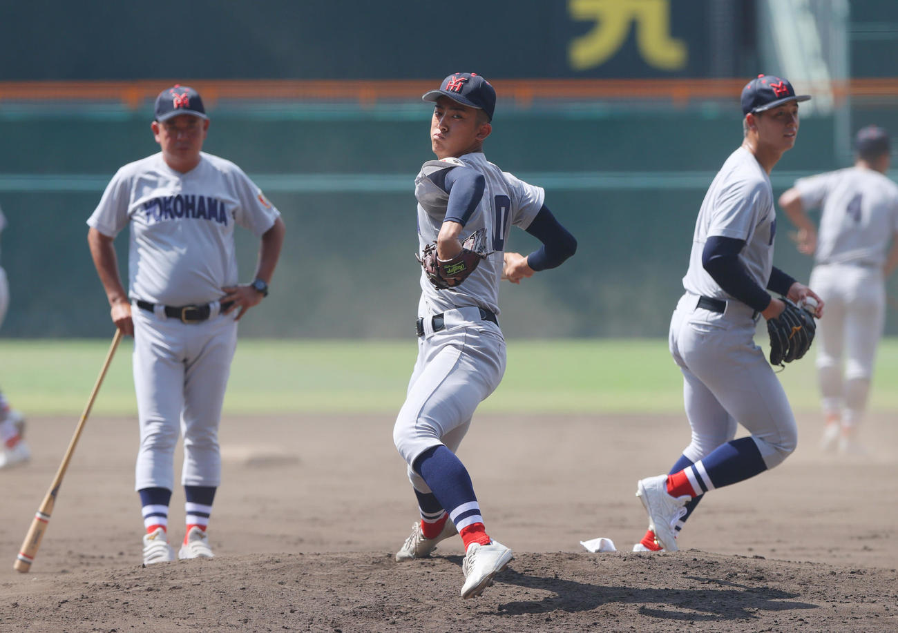 甲子園球場のマウンドで投球する横浜の織田。左は村田監督、右は奥村頼（撮影・上山淳一）