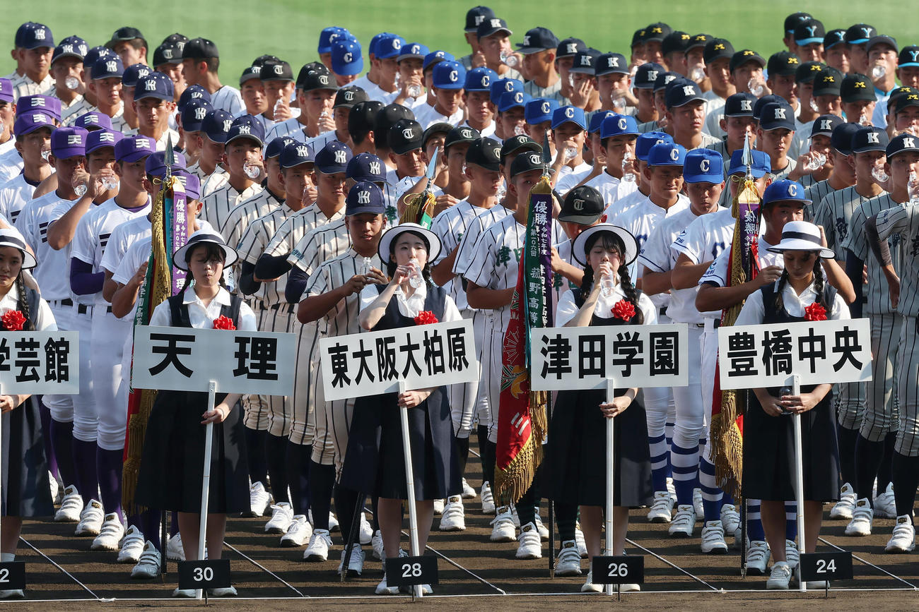 開会式のリハーサルの合間に水分補給をする選手たち（撮影・前田充）