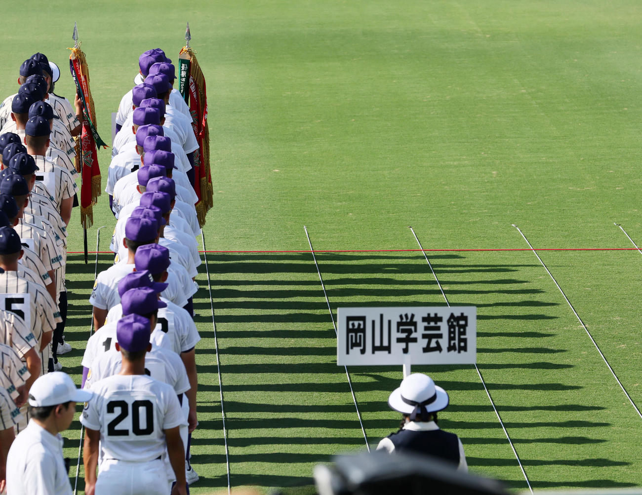 開会式で西日を受けて影が伸びる中を入場行進する選手たち（撮影・加藤哉）
