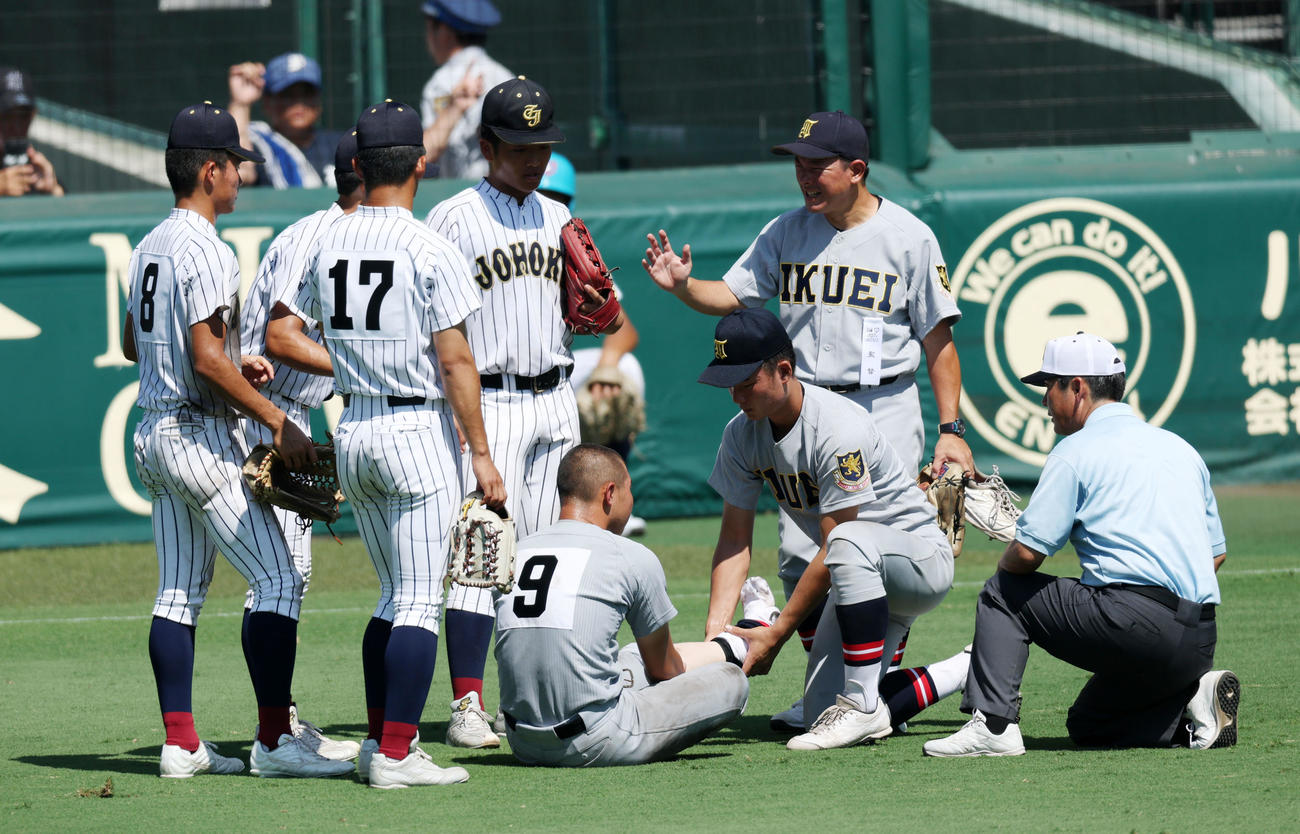 仙台育英対鳥取城北　8回裏を終えベンチへ引き揚げられずその場に座り込んだ仙台育英・田山纏（中央）に対し、水分補給やマッサージなどの手助けを行った鳥取城北ナインにお礼を伝える須江監督（撮影・加藤哉）