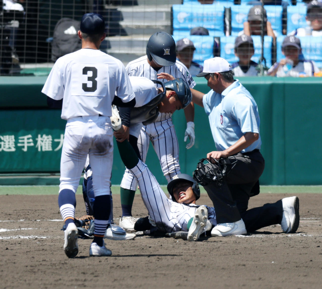 宮崎商対開星　8回裏開星2死一塁、打者小村は打席で足を痛め宮崎商・水谷捕手（左）が足首を持って手助けする（撮影・加藤哉）