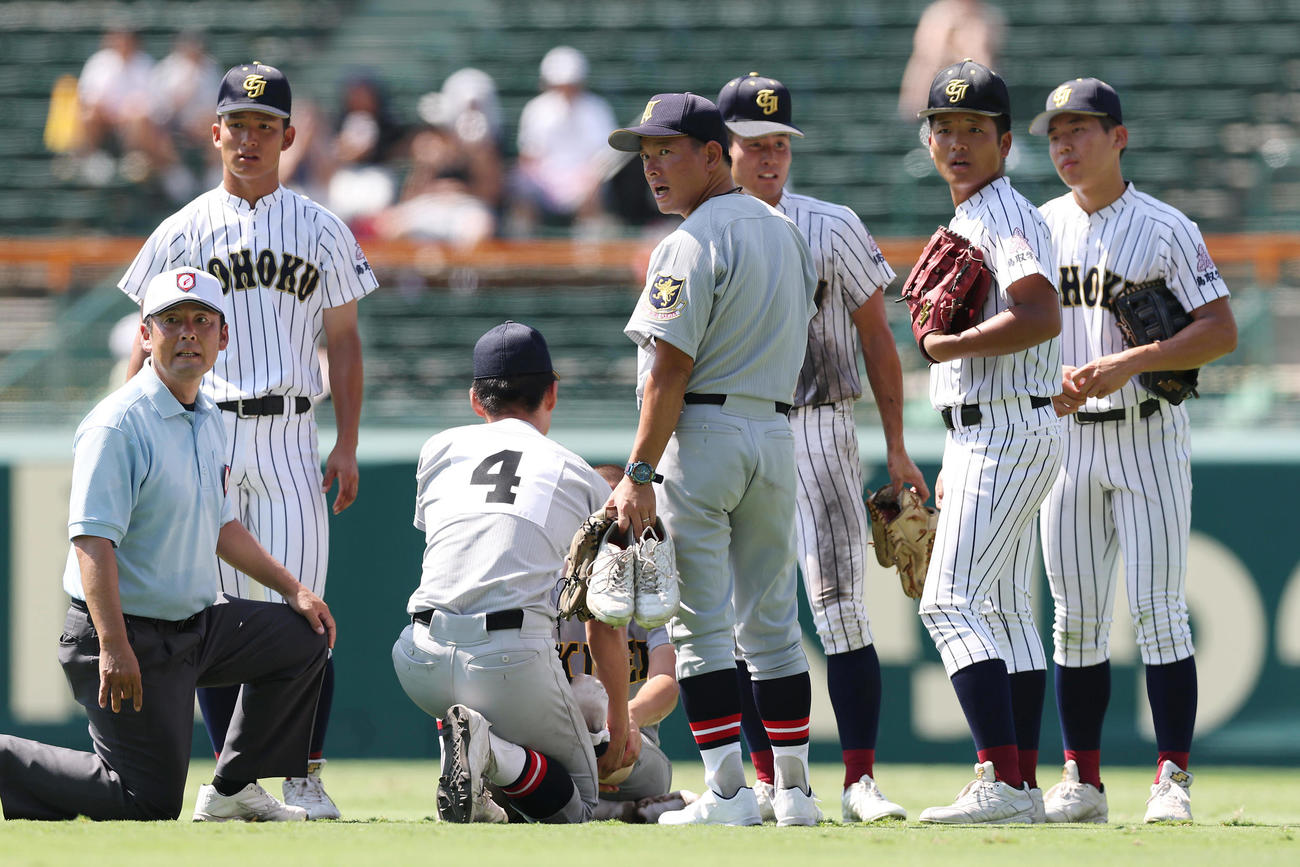 仙台育英対鳥取城北　8回裏の守備を終えたところで足をつった仙台育英・田山の元に心配そうに駆け寄った須江監督（中央）と鳥取城北の選手たち（撮影・前田充）