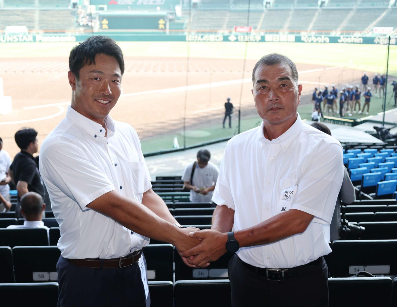 握手を交わす綾羽・千代監督（左）と高知中央・山野監督（撮影・増田悦実）