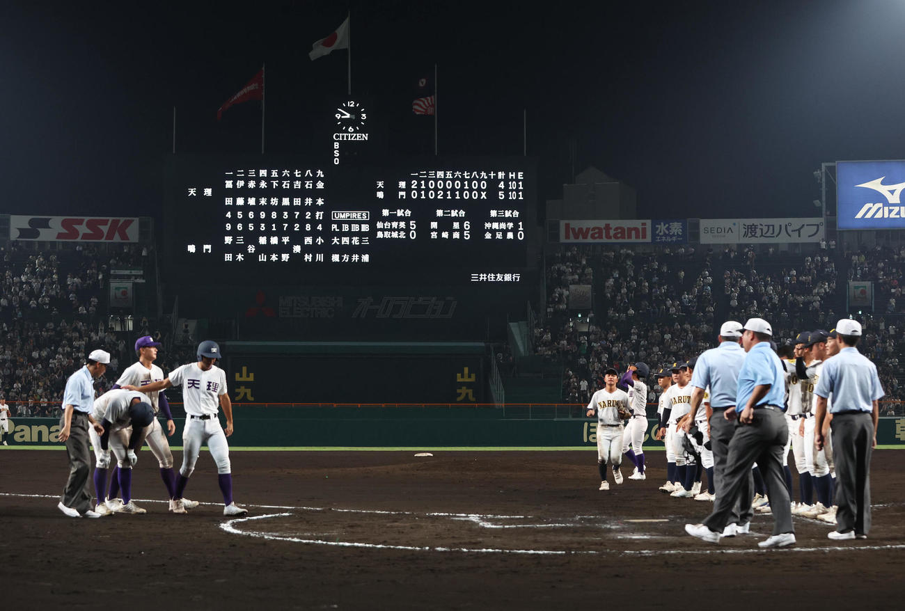 天理対鳴門　勝利して整列する鳴門ナイン（右）とがっくりと肩を落とす天理ナイン（撮影・白石智彦）