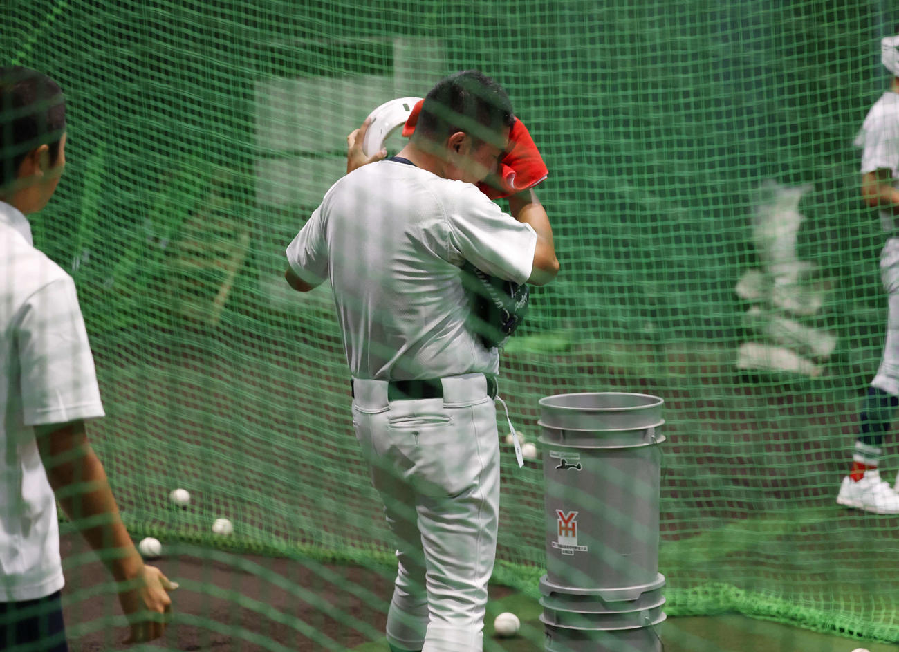 雨天中止となり、室内練習場でバッティングピッチャーを行い、汗を拭う村田監督（撮影・増田悦実）