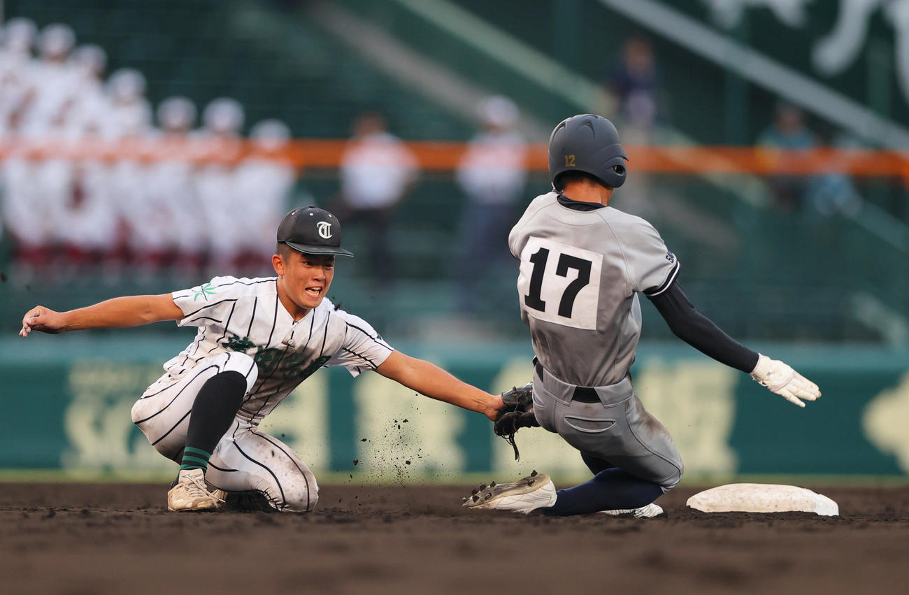 津田学園対叡明　9回表叡明2死一塁、打者根本の時、一走本間（右）は二盗を狙うもタッチアウト、遊撃手石井（撮影・上山淳一）