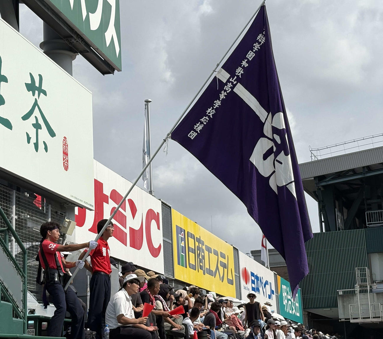 大きな旗を持ち智弁和歌山ナインに声援を送る谷本さん（左）と補助をする岩出さん（撮影・山本佳央）