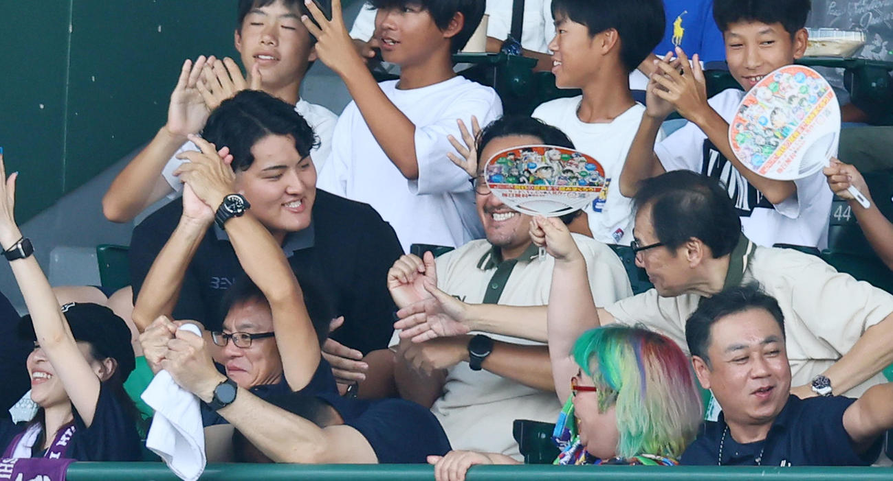 智弁和歌山対花巻東　試合を観戦した花巻東OBの佐々木麟太郎は勝利に近くの席の人と握手する（撮影・加藤哉）