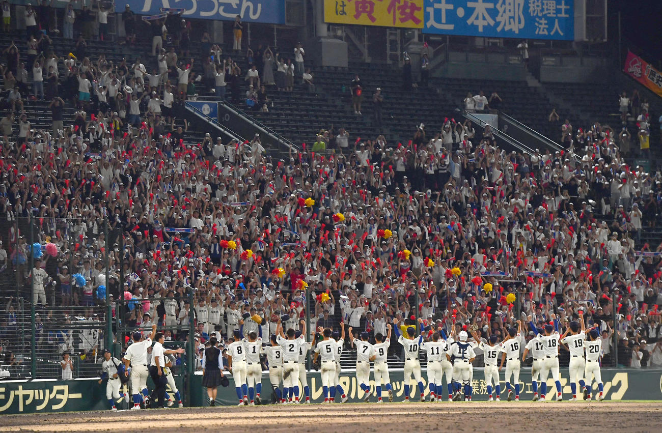 綾羽対高知中央　高知中央に勝利し、アルプススタンドの応援団にガッツポーズする綾羽ナイン（撮影・岩下翔太）