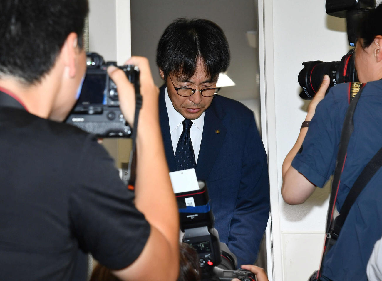 全国高等学校野球選手権大会の出場辞退会見を終え、報道陣に一礼して会場を後にする広陵堀校長（撮影・岩下翔太）