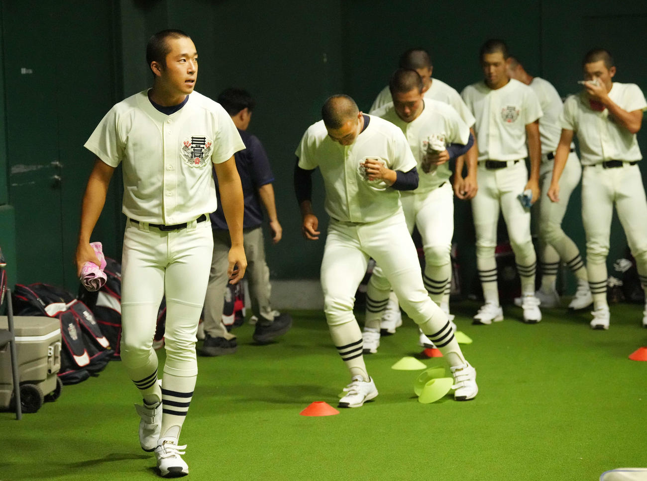 室内で練習し、ウオーミングアップする日大三・本間主将（左）とナイン（撮影・小島史椰）