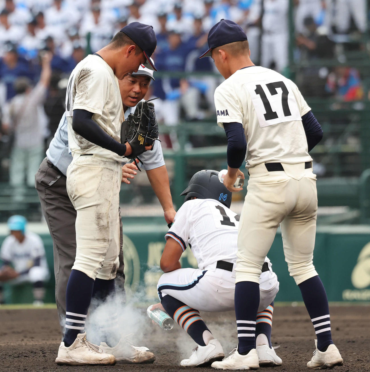 高川学園対未来富山　9回表高川学園無死一塁、左足に異常を訴えた松井投手の元に駆けつけ、冷却スプレーをかける高川学園の三塁コーチャー木寺（撮影・西尾就之）