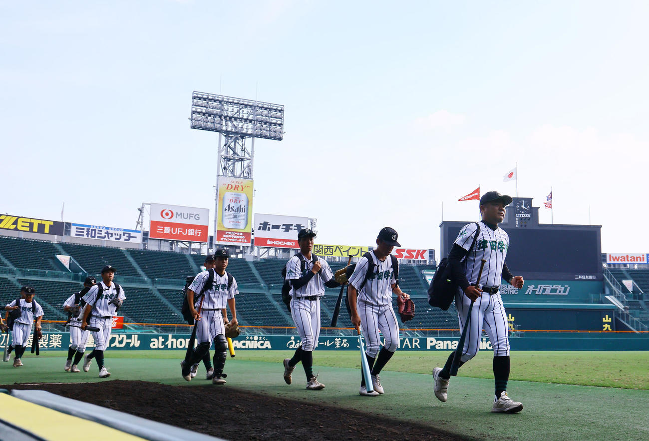 甲子園での練習で、グラウンドに入る佐川監督（右端）ら津田学園の選手たち（撮影・藤尾明華）