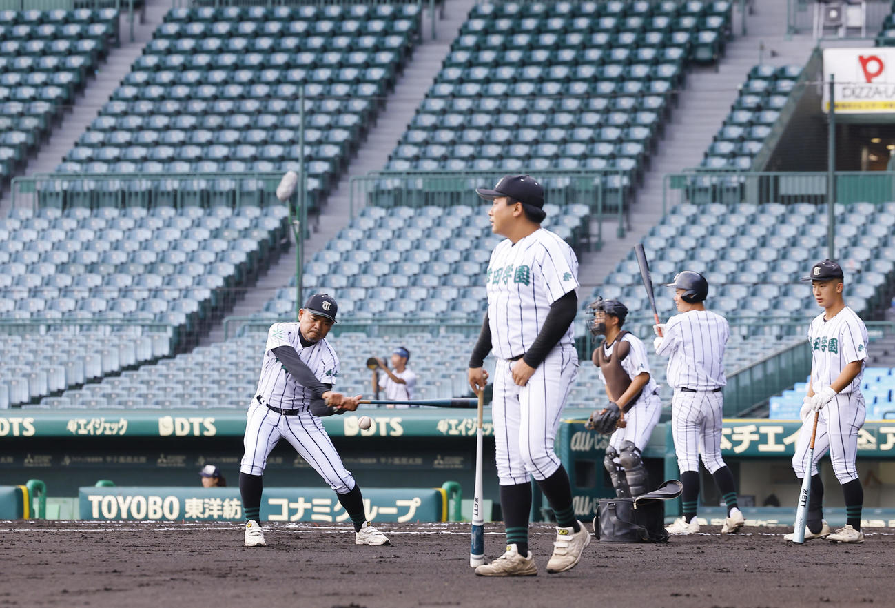甲子園練習でノックを打つ津田学園・佐川監督（撮影・藤尾明華）