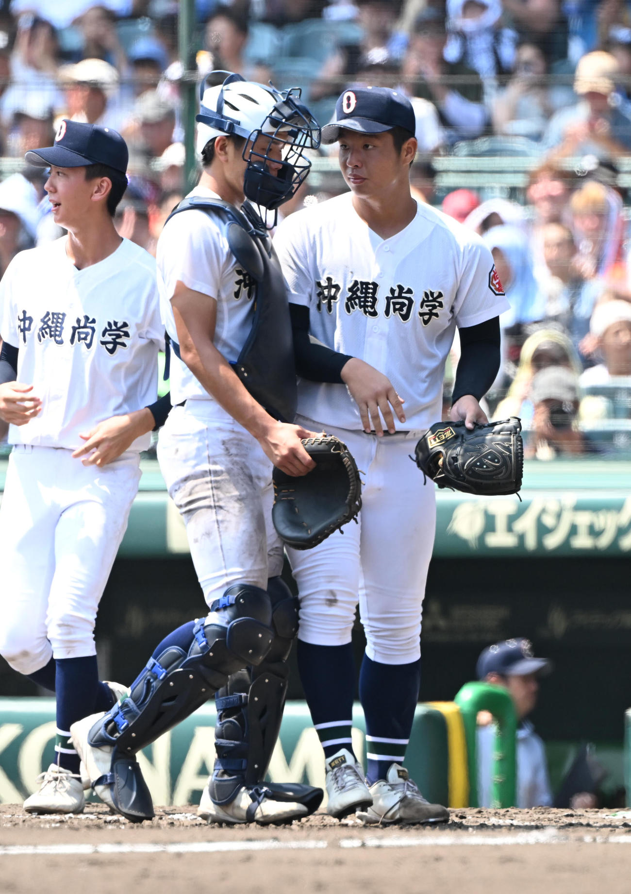 沖縄尚学対鳴門　9回裏鳴門2死、最後の打者を中飛に打ち取った末吉（右）は捕手宜野座とタッチ（撮影・和賀正仁）