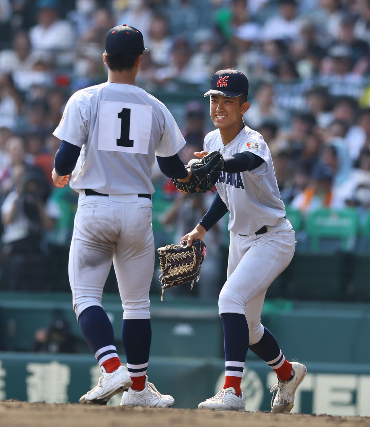 横浜対綾羽　9回途中、3番手で登板する奥村頼（左）にボールを渡す横浜・織田（撮影・藤尾明華）