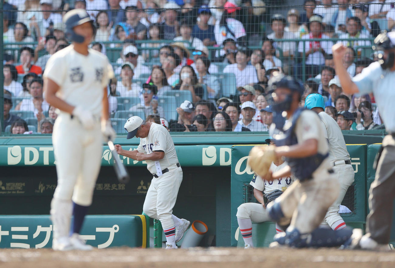東洋大姫路対西日本短大付　7回裏西日本短大付2死一、二塁、岡田監督（中央）は投手木下が安田を見逃し三振に仕留めガッツポーズする（撮影・上山淳一）