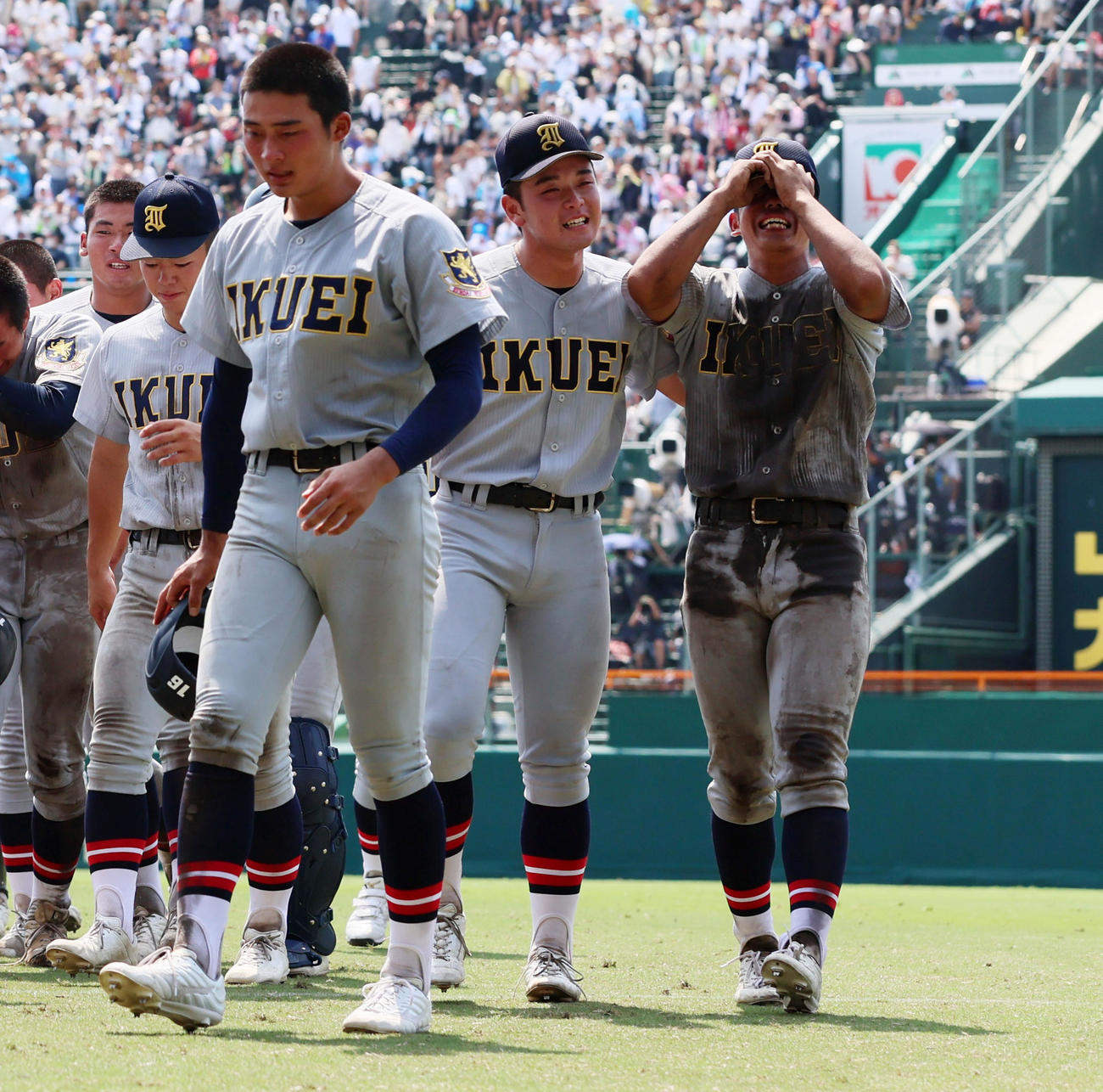 沖縄尚学対仙台育英　試合後のあいさつを終え号泣するナインに声を掛ける仙台育英・佐々木主将（撮影・加藤哉）