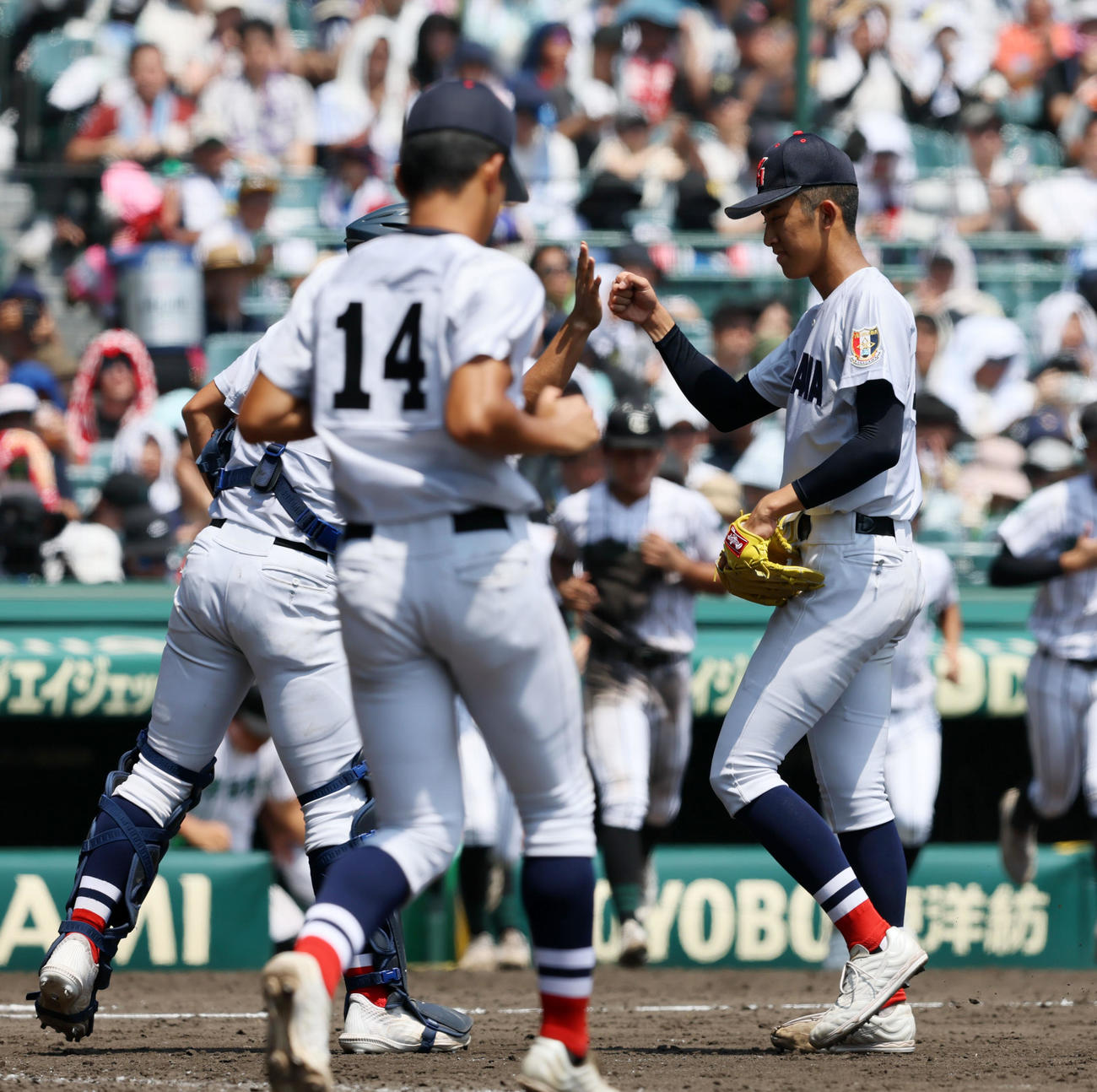 横浜対津田学園　津田学園に勝利し駒橋（左）らナインとタッチする横浜・織田（撮影・加藤哉）