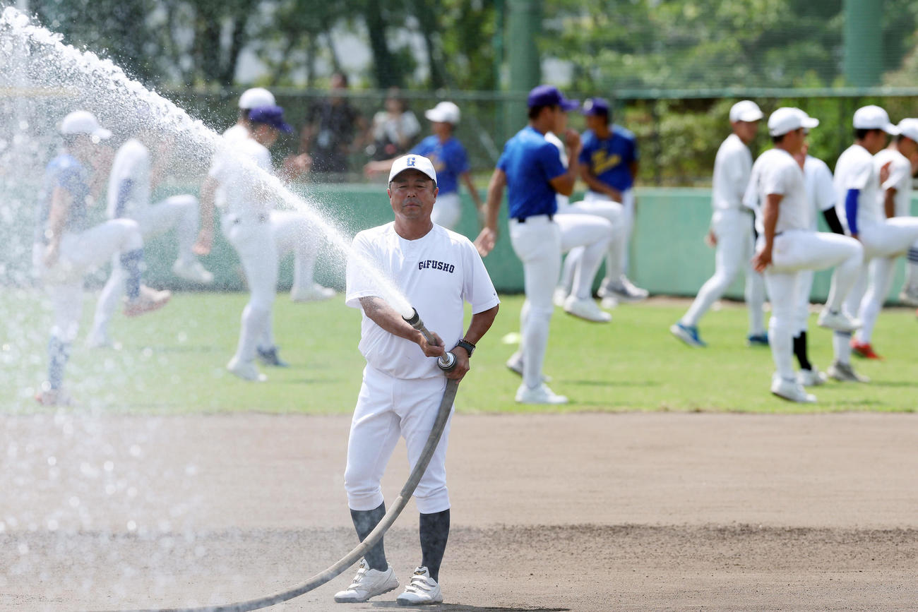 内野グラウンドに散水する県岐阜商・藤井監督（撮影・前田充）