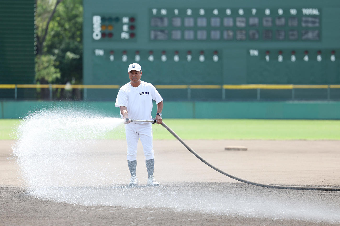 内野グラウンドに散水する県岐阜商・藤井監督（撮影・前田充）