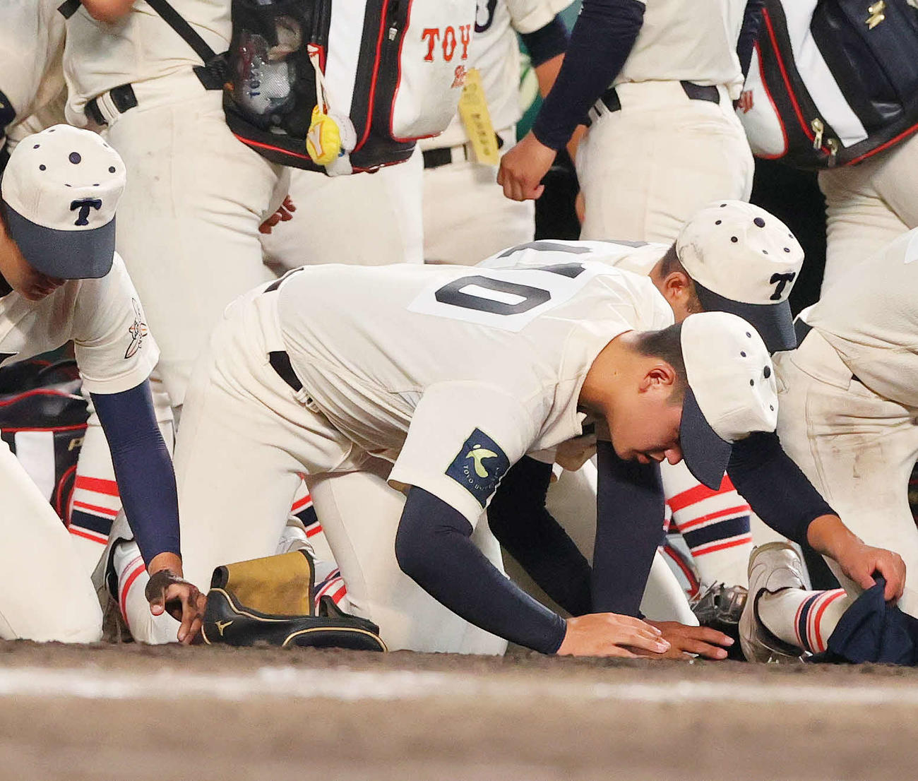 沖縄尚学対東洋大姫路　沖縄尚学に敗れた東洋大姫路の阪下（中央）は甲子園の土を拾う（撮影・上山淳一）