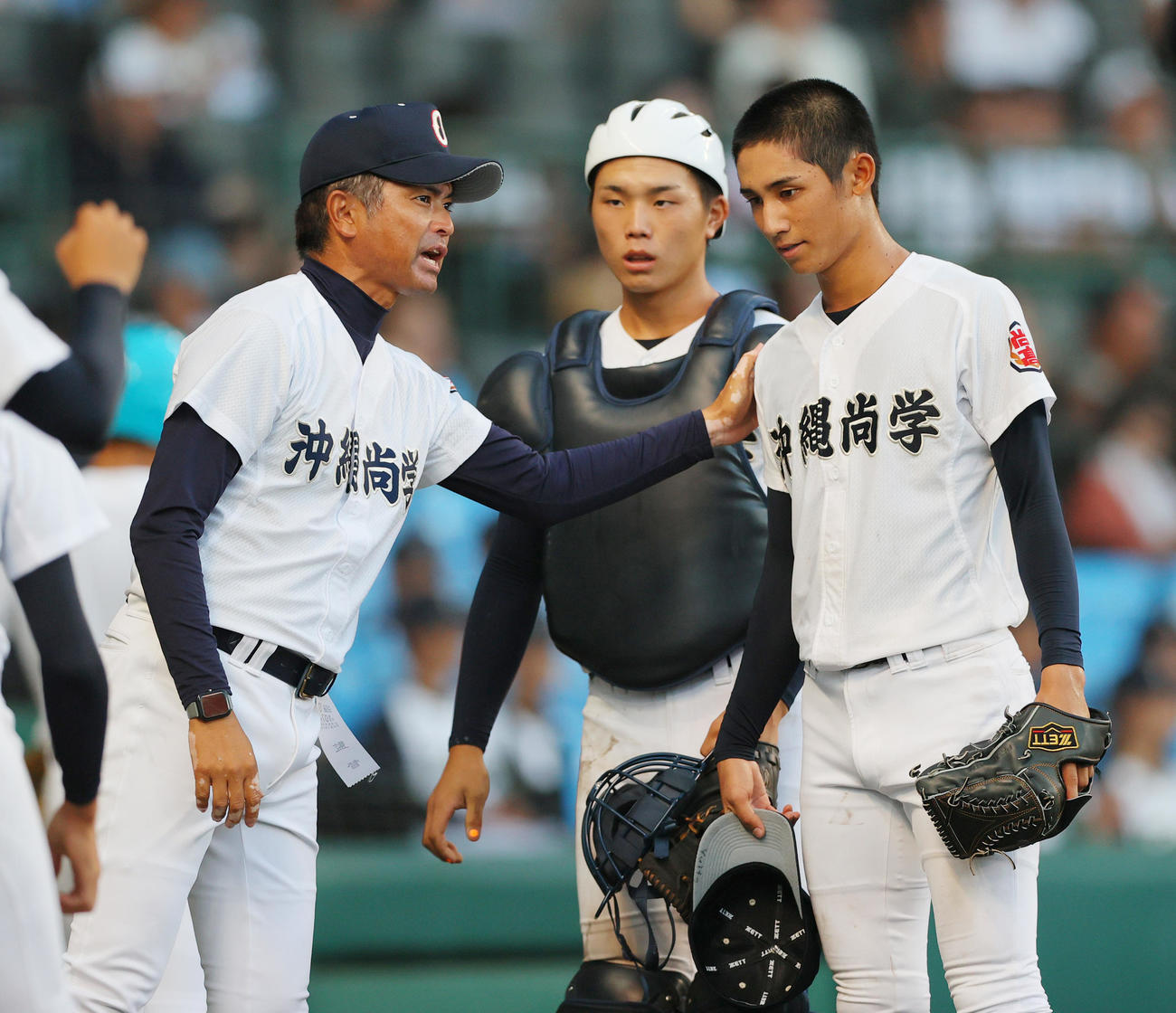 沖縄尚学対東洋大姫路　6回裏を無失点に抑えた新垣有（右）に声を掛ける比嘉監督。中央は捕手宜野座（撮影・上山淳一）