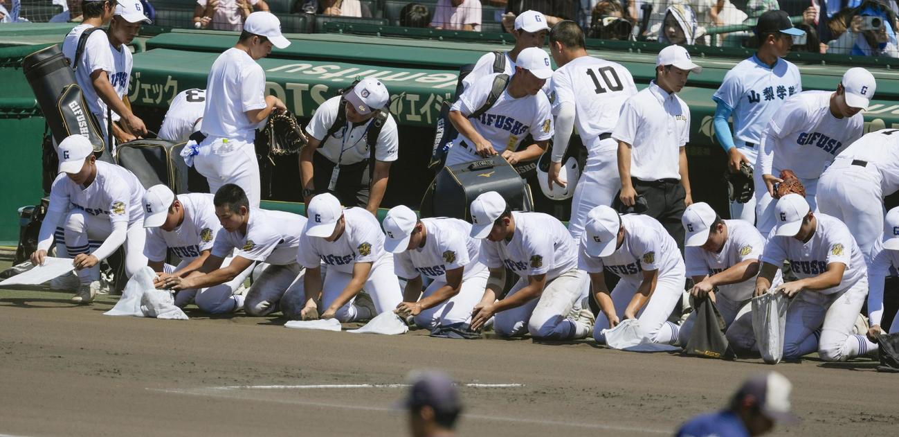 タイブレークで日大三に敗れ、グラウンドの土を集める県岐阜商ナイン（共同）