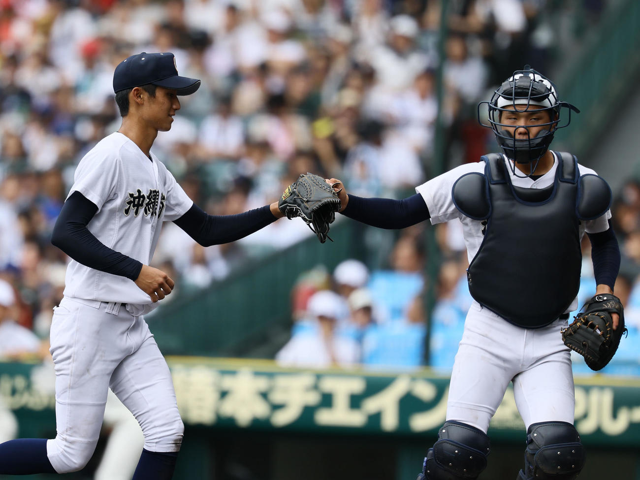 沖縄尚学対日大三　6回を終えタッチを交わす沖縄尚学・新垣有（左）と宜野座（撮影・藤尾明華）