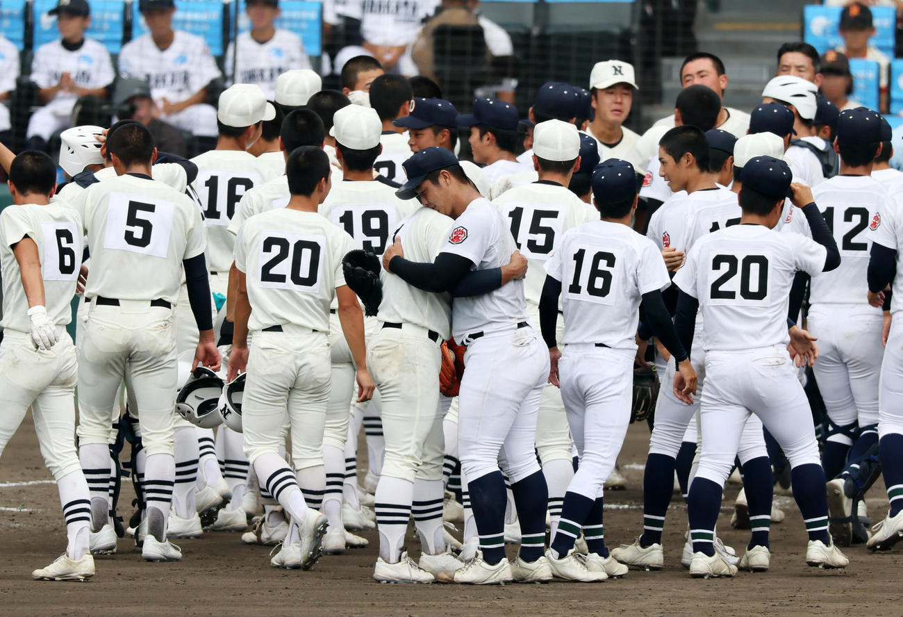 沖縄尚学対日大三　試合終了のあいさつを終え抱き合う日大三・近藤（左）と沖縄尚学・末吉（撮影・加藤哉）