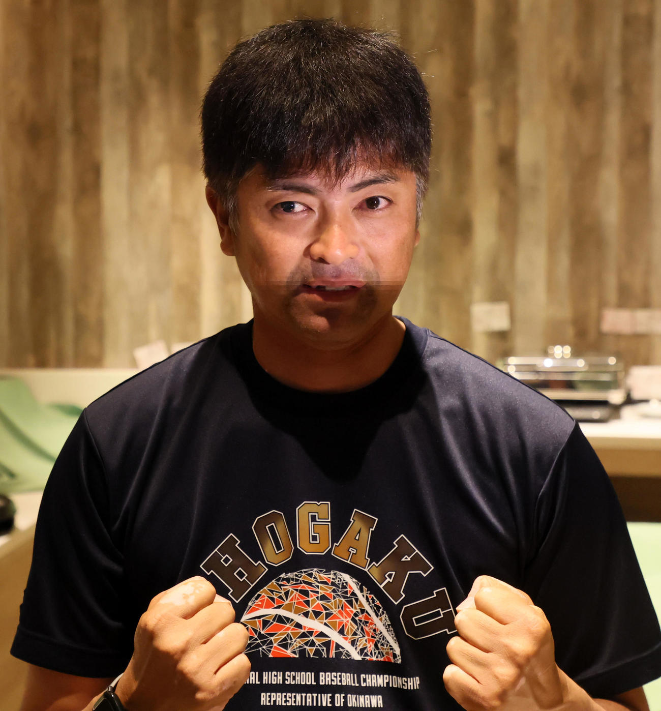 宿舎でガッツポーズを見せる沖縄尚学の比嘉監督（撮影・加藤哉）