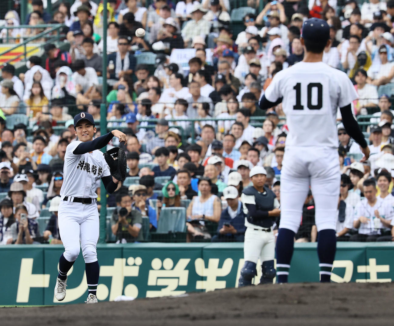 沖縄尚学対日大三　試合が始まり、新垣有（右）にボールを渡す兄新垣瑞（撮影・藤尾明華）