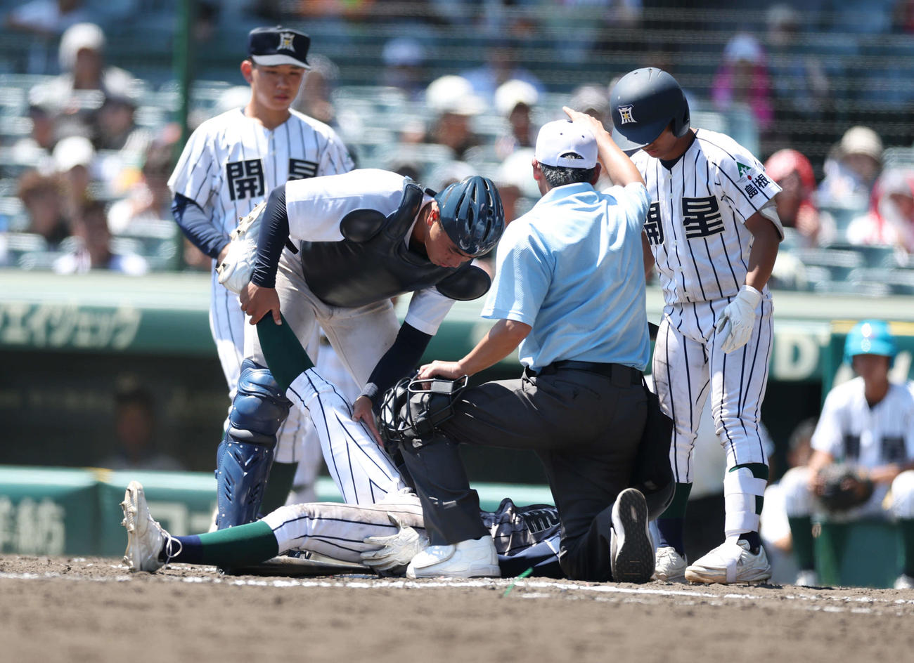 宮崎商対開星　8回裏開星　開星・小村（中央下）が足をつり、宮崎商・水谷（中央上）が伸ばす（2025年8月6日撮影）