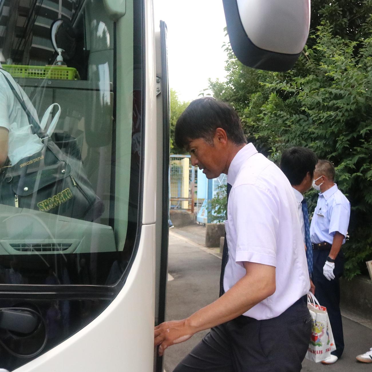 沖縄尚学の比嘉監督が荷物を手にバスに乗り込む（撮影・林亮佑）