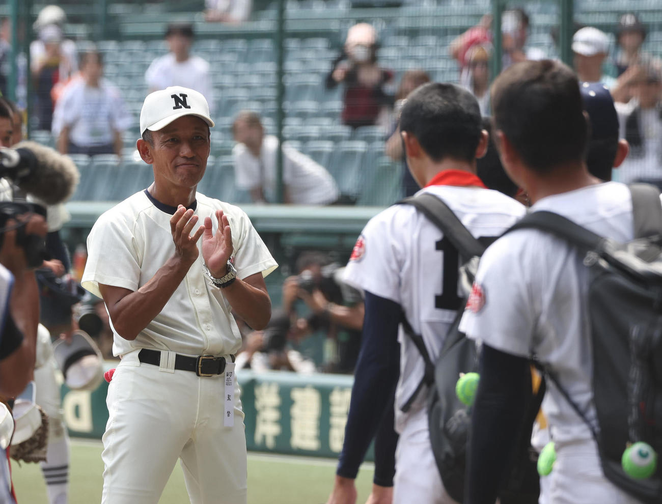 沖縄尚学対日大三　優勝した沖縄尚学ナインを拍手で見送る日大三・三木監督（左）（撮影・白石智彦）