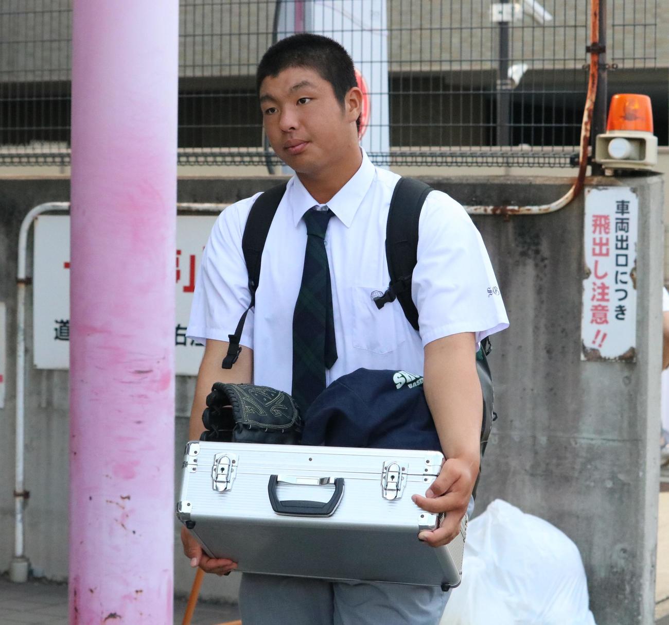 沖縄尚学の末吉が野球道具などを手に帰路につく（撮影・林亮佑）