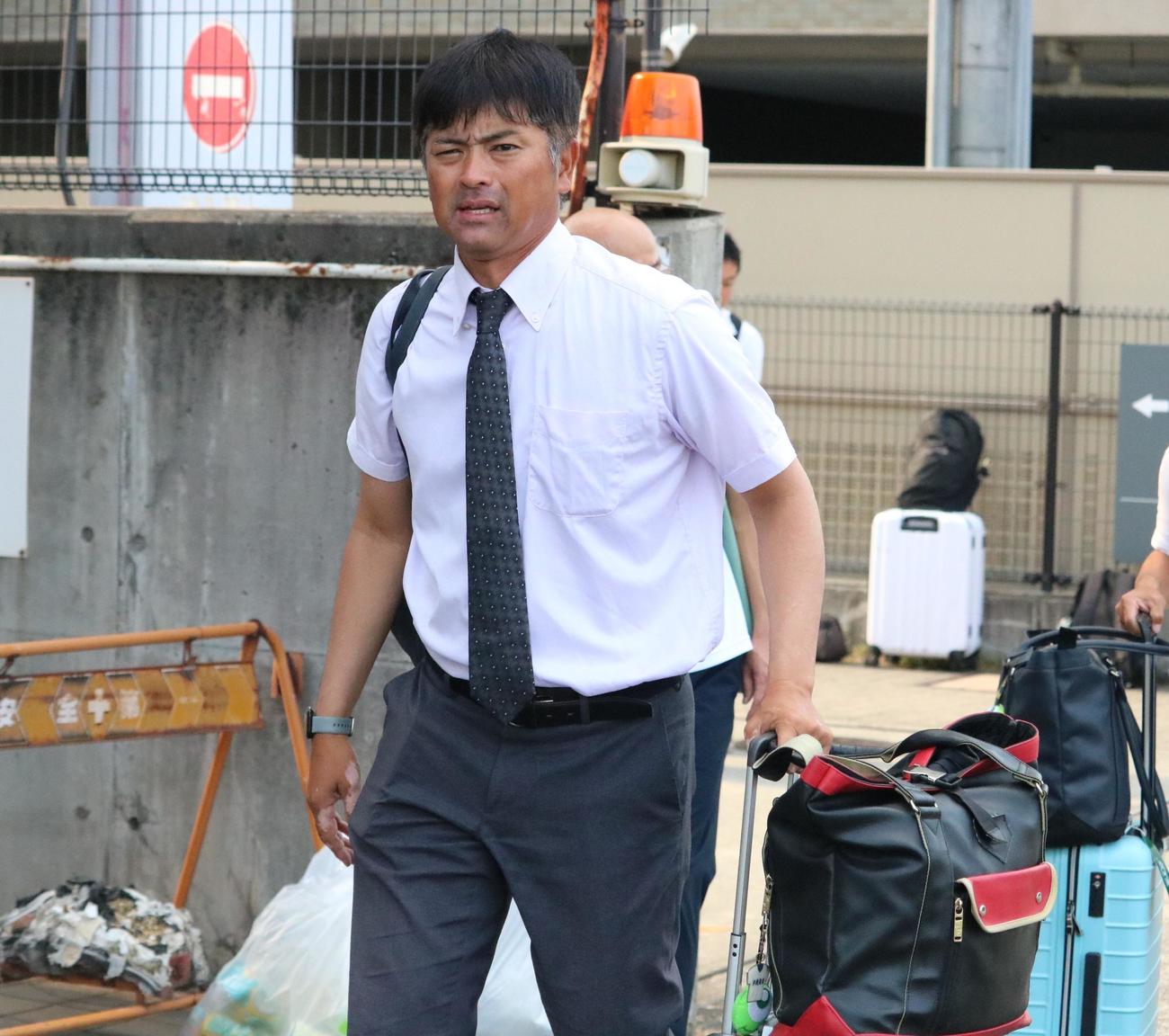 沖縄尚学の比嘉監督が荷物を手に帰路につく（撮影・林亮佑）