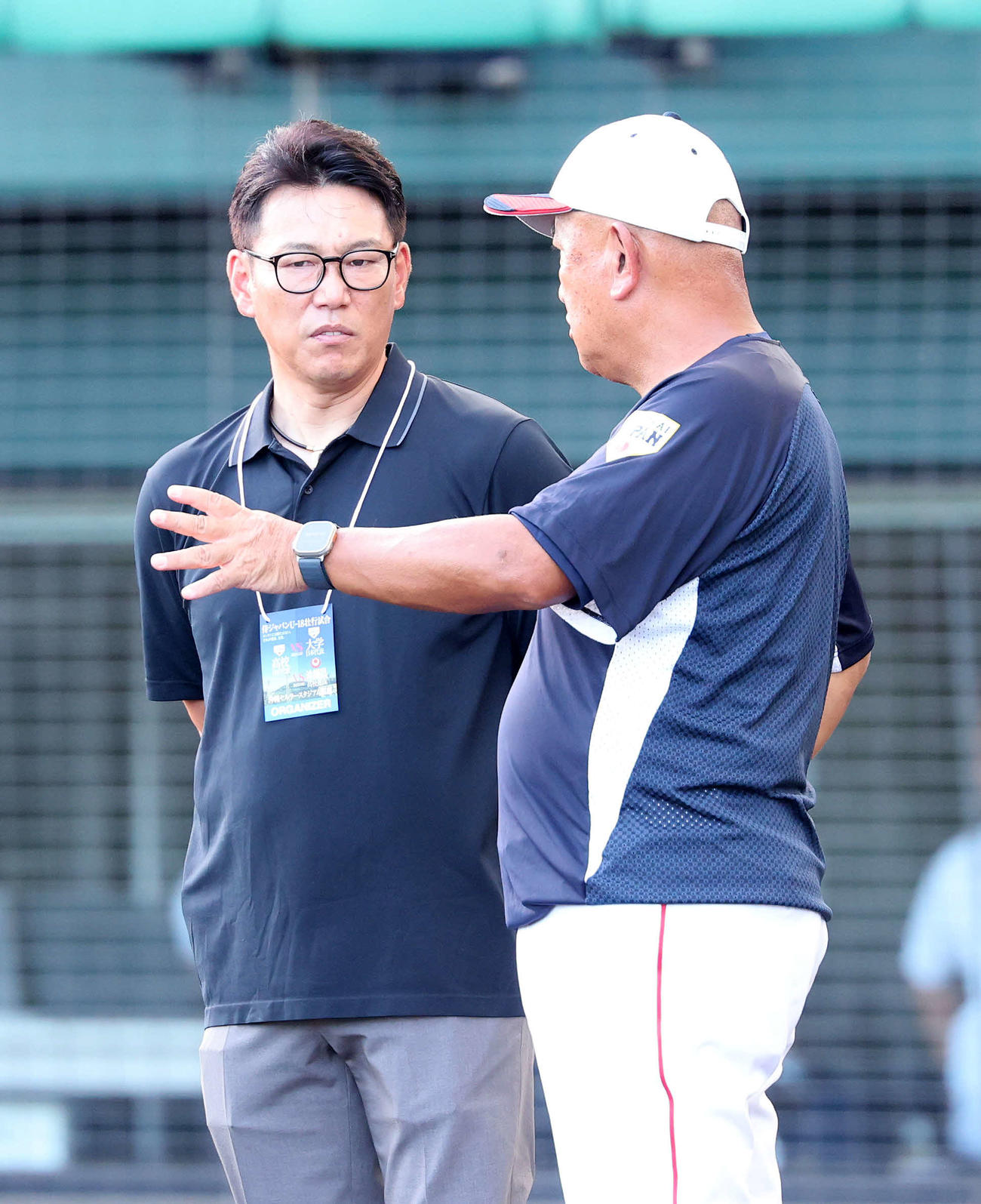 大学日本代表対高校日本代表　練習中、大学日本代表・堀井監督（右）と話す侍ジャパン井端監督（撮影・鈴木正人）