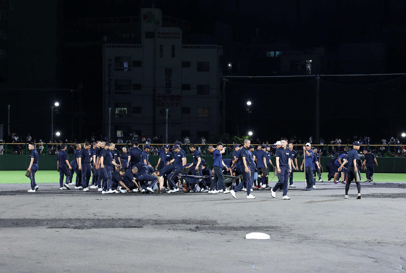 高校日本代表対沖縄県高校選抜　試合再開にむけグランド整備する沖縄尚学野球部の選手たち（撮影・鈴木正人）