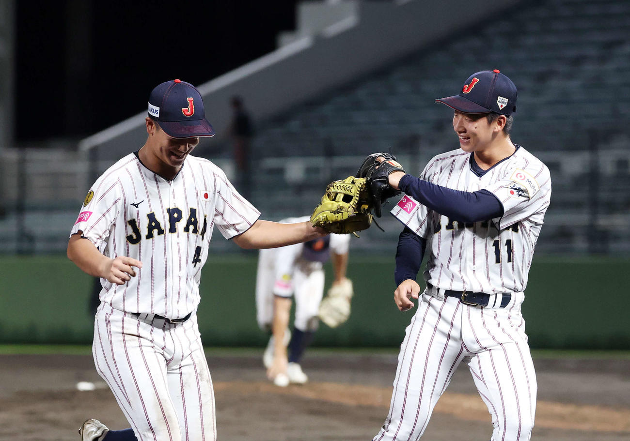 イタリア対日本　5回表、イタリアのの攻撃を抑えグラブタッチする日本・奥村凌（左）と森下（撮影・鈴木正人）