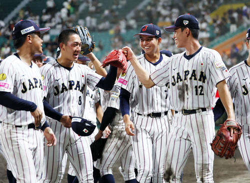 韓国対日本　勝利し選手たちに迎えられる日本・石垣（左から2人目）（撮影・鈴木正人）