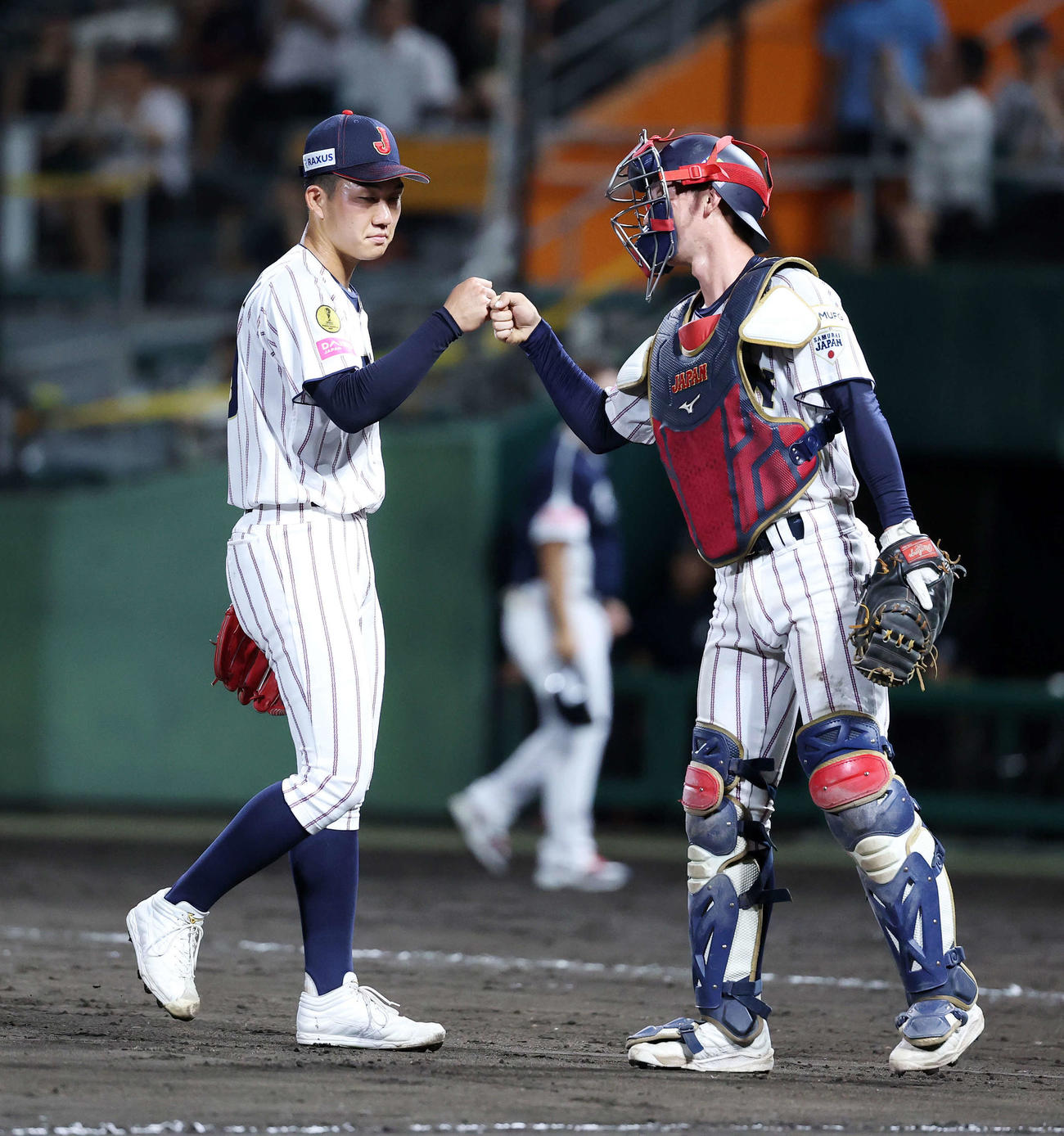 韓国対日本　勝利しグータッチする日本・石垣（左）と横山（撮影・鈴木正人）